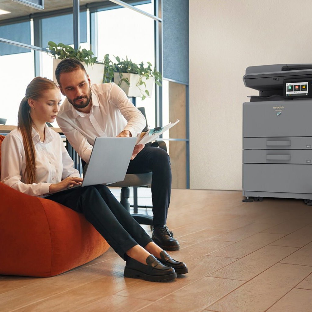 Man and woman employees working on a laptop in the office